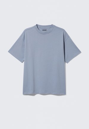 Lichtblauw T-shirt met korte mouwen van katoen. Heeft een ronde halslijn en een relaxte pasvorm, met subtiele stiksels op de schouders.