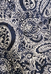 Granatowa i biała bawełniana tkanina z misternymi wzorami paisley i kwiatowymi. Teksturowana, z falistymi wzorami i szczegółową liniową pracą w całej tkaninie.