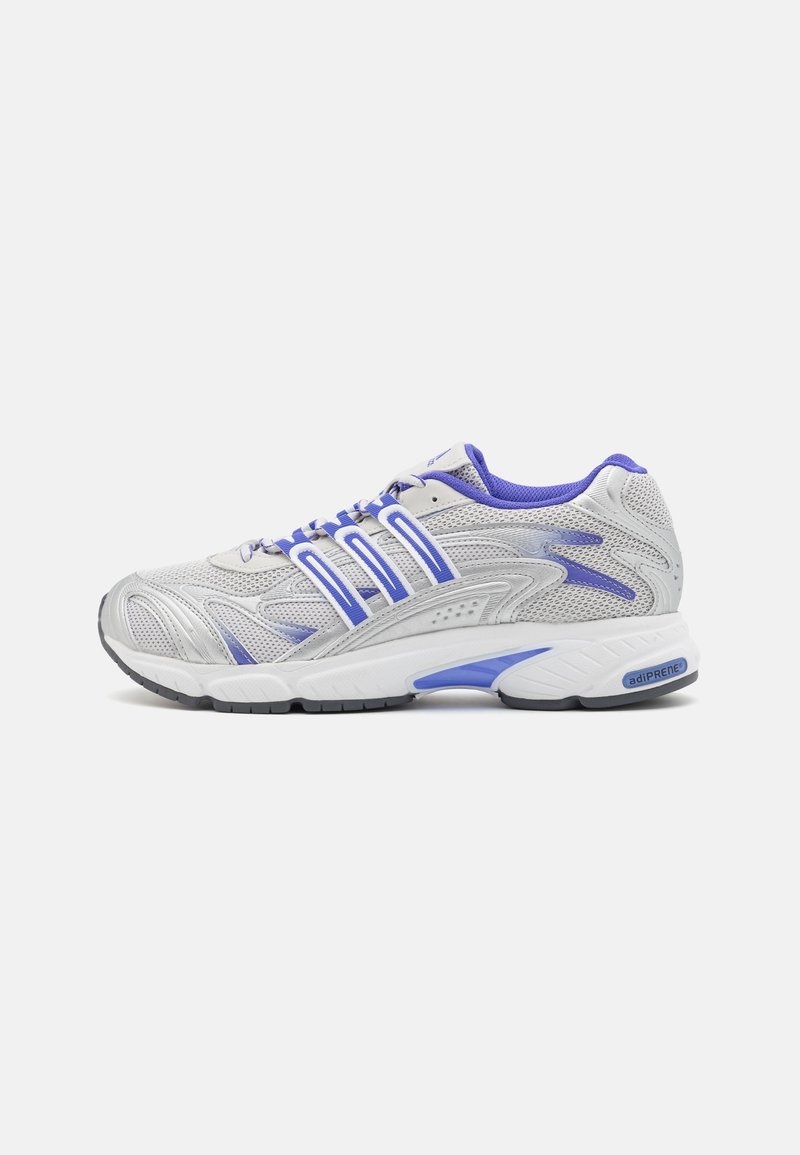 Chaussure de course blanche et violette avec tige en mesh, bandes latérales de soutien, semelle amortissante marquée "adiprene" et semelle extérieure noire crantée.