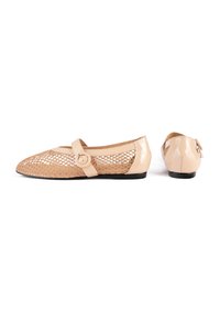 Beige patent leather flats with a mesh upper, rounded toe, and a decorative strap featuring a circular button detail.
