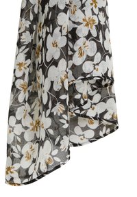 Tissu transparent à motif floral blanc et marron sur fond sombre, présenté drapé avec plis visibles et couture de l'ourlet.