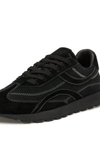 Baskets en suède noir avec des coutures blanches contrastantes, des lacets ronds et une semelle en caoutchouc texturée. Présentent un design de vague iconique sur le côté.