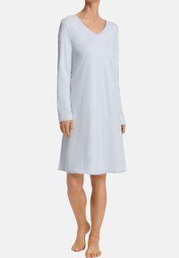 Světle modrý noční úbor s dlouhým rukávem a výstřihem do V, vyrobený z měkké látky, má uvolněný střih a končí těsně nad koleny.