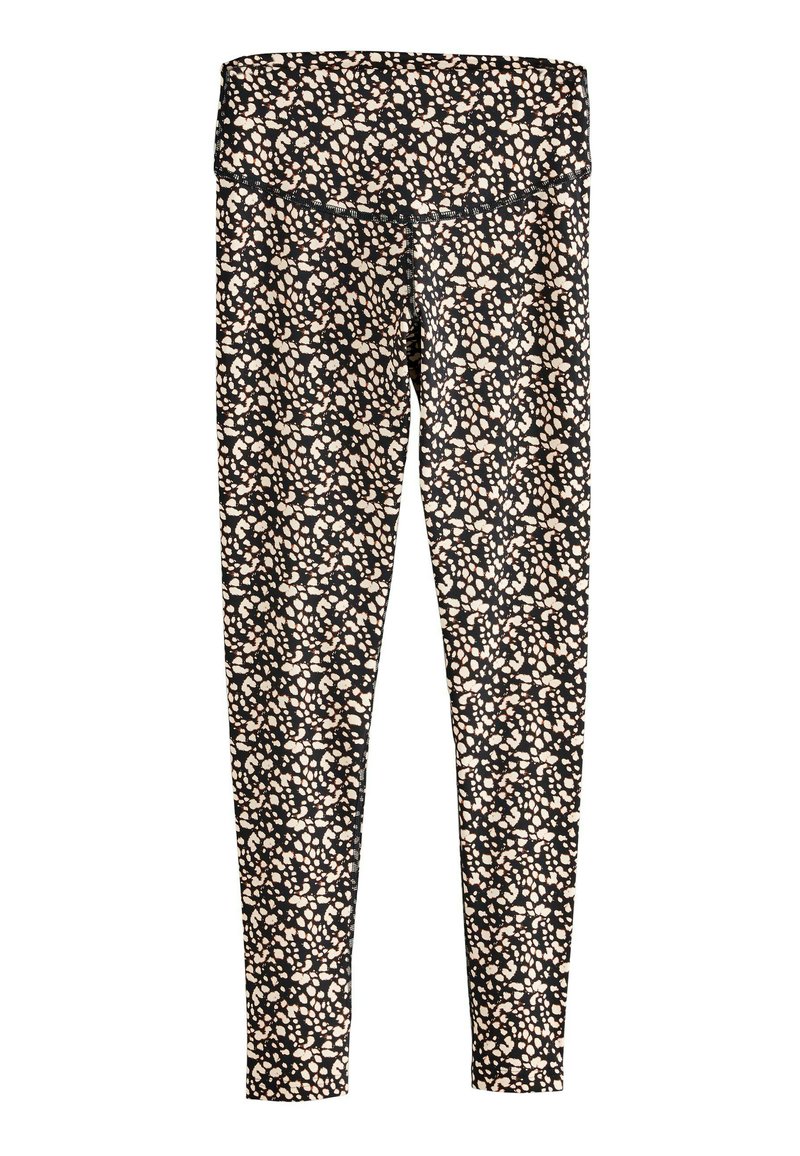 Leggings negros con un estampado floral en rosa y blanco. Cintura alta con una textura suave. Diseño ajustado que se estrecha hacia el tobillo.