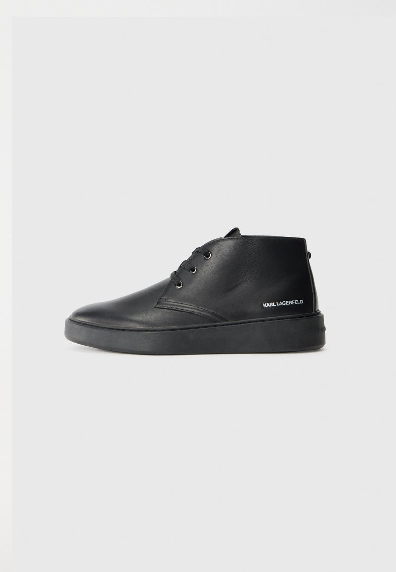 Botas de tobillo de cuero negro con puntera redonda, dos ojales y una suela texturizada. Presenta un logo de 'KARL LAGERFELD' en el lateral.