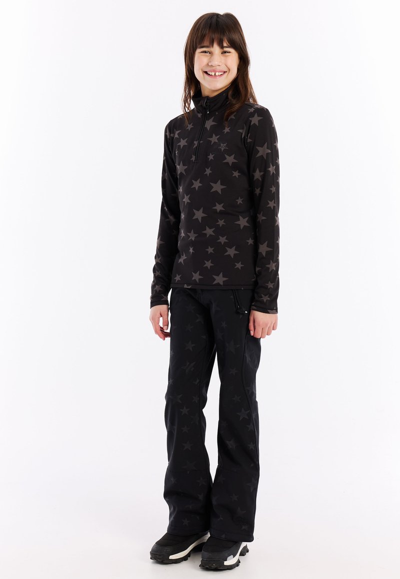 Haut noir à manches longues avec un motif d'étoiles grises, col zippé, associé à un pantalon noir présentant un design d'étoiles similaire, porté avec des bottes noires.