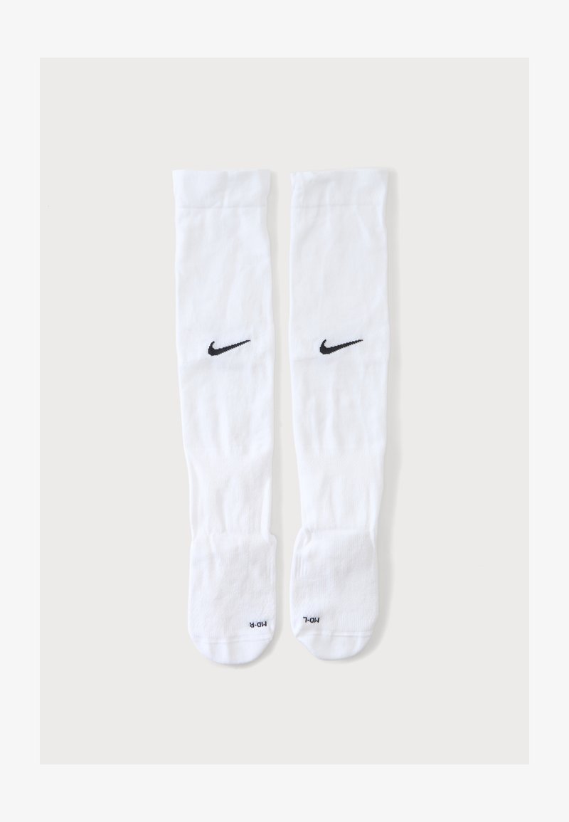 Ζευγάρι λευκές κάλτσες Nike μέχρι το γόνατο με μαύρα λογότυπα Swoosh και ετικέτες με το μέγεθος στο τμήμα των ποδιών, εμφανιζόμενες σε απλό φόντο.
