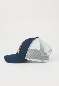 Gorra de béisbol azul marino con un panel frontal sólido y parte trasera de malla blanca. Presenta un parche en la parte delantera con un diseño naranja y negro.