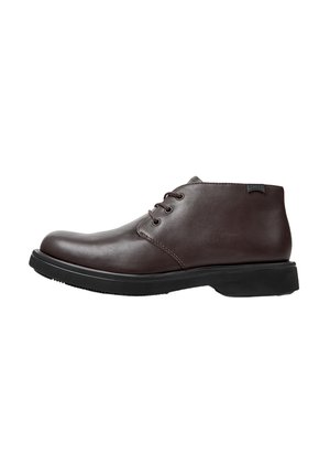 Brown leather ankle boot with a rounded toe, six eyelet lacing, and a black rubber sole. Subtle stitching and a brand tag on the side.