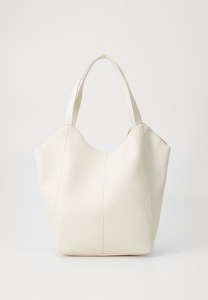 Sac cabas en cuir souple couleur crème avec deux anses, coutures apparentes et bord supérieur légèrement incurvé, posé sur un fond blanc uni.