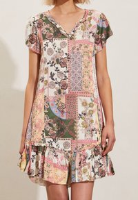 Sukienka z krótkim rękawem, w stylu patchwork, z kwiatowymi i geometrycznymi wzorami w odcieniach różu, zieleni i kremu, z falbaniastym dołem i dekoltem w kształcie litery V.