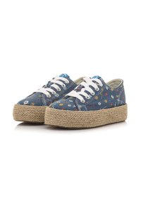 Baskets en denim bleu avec un motif floral, lacets blancs et semelle en jute. Présentent un bout arrondi et un design bas.