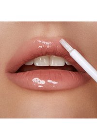 Lucidalabbra in una tonalità nude applicato su labbra piene. Finitura lucida con una consistenza morbida e liscia. L'applicazione avviene con un applicatore bianco.