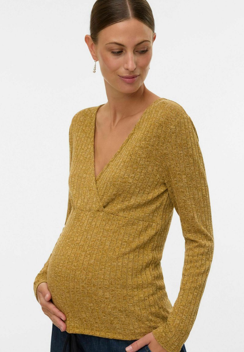 Haut de maternité côtelé jaune moutarde avec un décolleté en V profond, des manches longues et une taille ajustée, permettant de mettre en valeur le confort et l'ajustement pendant la grossesse.