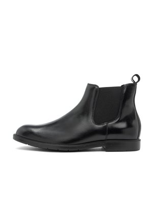 Botín Chelsea de cuero negro con paneles laterales elásticos, puntera redondeada y tira de agarre. Acabado suave, tacón bajo y suela de goma texturizada.