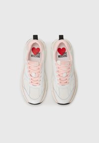 Weiße Sneakers mit rosa Schnürsenkeln, aus Mesh- und Synthetikmaterial, runde Form, gepolsterter Schaft, schwarze Gummisohle, "LOVE MOSCHINO" Logo auf der Innensohle.