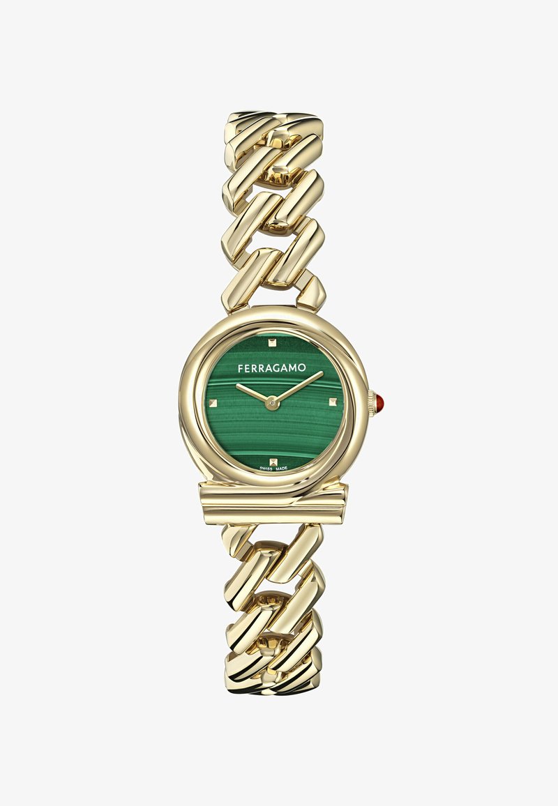 Arany színű karóra masszív lánc karkötővel, zöld malachit számlappal, arany színű órajelzőkkel és piros kiegészítéssel a koronán.
