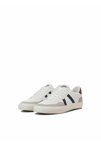 Witte sneakers met grijs suède accenten en marineblauwe strepen, rubberen zool, vetersluiting en een klein rood accent op de hiel.