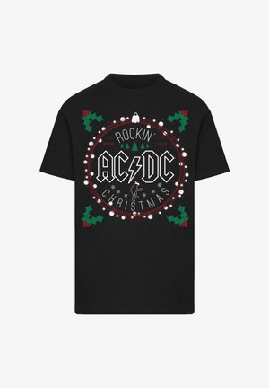 Zwart katoenen T-shirt met een cirkelvormige grafische afbeelding met de tekst "AC/DC", kerstverlichting, hulstbladeren en een beer met een kerstmanmuts.