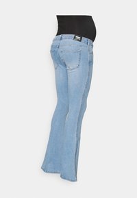Jeans de ganga azul clara com um design de perna larga, apresentam uma cintura média e dois bolsos traseiros. Costura visível e uma etiqueta na parte de trás.