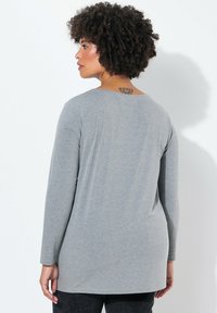 Grijze tuniek met lange mouwen, gemaakt van zachte stof, met een ronde halslijn en een ontspannen pasvorm, met een rechte zoom in de taille.