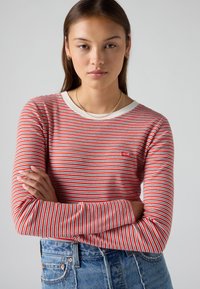 Långärmad randig skjorta med röda och vita horisontella ränder, ribbad halsringning och liten Levi's-logotyp på bröstet. Matchad medjeans.