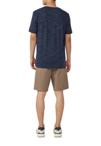 Marineblauwe heather t-shirt met korte mouwen, gecombineerd met beige shorts en witte sneakers met donkere accenten. Zachte textuur, casual pasvorm.
