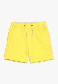 Žluté plavky vyrobené z lehké látky, s elastickým pasem na šňůrku a dvěma bočními kapsami. Hladký povrch.