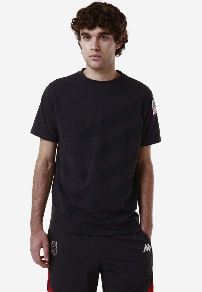 T-shirt nera a maniche corte con un motivo star texturizzato, caratterizzata da una toppa con la bandiera americana sulla manica sinistra. Design semplice, collo tondo.