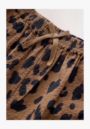 Barna szövetnadrág rövidnadrág, texturált felülettel, fekete pöttyös mintával és elasztikus derékpánttal, mely állítható húzózsinórral rendelkezik.