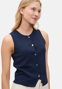 Navy ärmelloses Oberteil aus strukturiertem Stoff mit Rundhalsausschnitt und fünf silbernen Knopfverschlüssen an der Vorderseite, leicht abgerundeter Saum.
