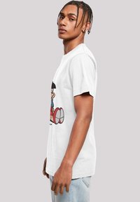 White cotton t-shirt featuring a cartoon graphic on the front. Short sleeves, round neckline, and relaxed fit. Casual and lightweight design.