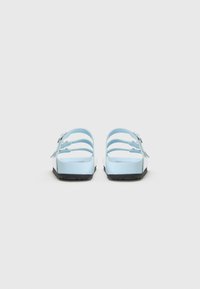 Blue rubber sandals with multiple straps, flat soles, and a textured black bottom. Designed for comfort and ease of wear.