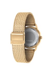 Montre en acier inoxydable doré avec un bracelet en mailles tressées, présentant un boîtier rond et un cadran lisse et transparent affichant le logo de la marque.