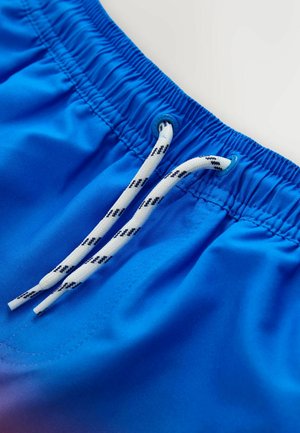 Modré plavecké šortky s elastickým pásom, bielym sťahovacím šnúrom s čiernymi akcentmi a hladkou textúrou látky.