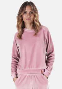 Felpa rosa in velluto con collo a giro, polsini a coste e vestibilità comoda. Presenta una texture morbida e un piccolo etichetta del marchio sul lato.