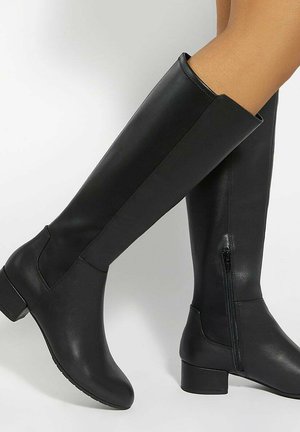 Knee-high black leather boots with a rounded toe, chunky heel, smooth texture, and side zipper. Minimalistic design with no additional patterns.
