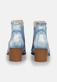 Botas de tobillo de cuero azul claro con un acabado texturizado, punta redondeada y un tacón de madera de altura media. Cuenta con una lengüeta en la parte posterior.