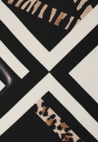 Geometric scarf featuring a mix of black, white, and beige patterns, including animal prints and stripes on a smooth fabric surface.