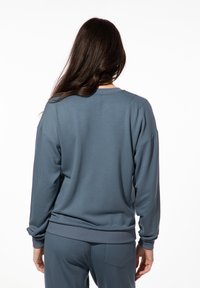 Blauwe sweatshirt met lange mouwen, ronde hals en geribbelde manchetten. Zacht katoenmix materiaal, met een relaxte pasvorm.