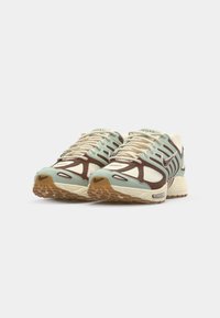 Baskets Nike Pegasus avec un schéma de couleurs bleu clair, marron et crème. Tige en mesh texturé avec des accents renforcés et une semelle en caoutchouc.
