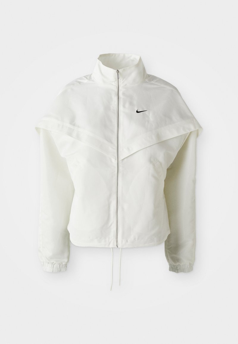 White long-sleeve zip-up jacket with high collar, cape-like detail across shoulders, elastic cuffs, and small black Nike logo on chest.