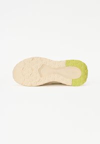 Beige cipőtalp mintás felülettel; zöld kiemelés a sarkán; texturált tapadás kör- és ovális formákkal.