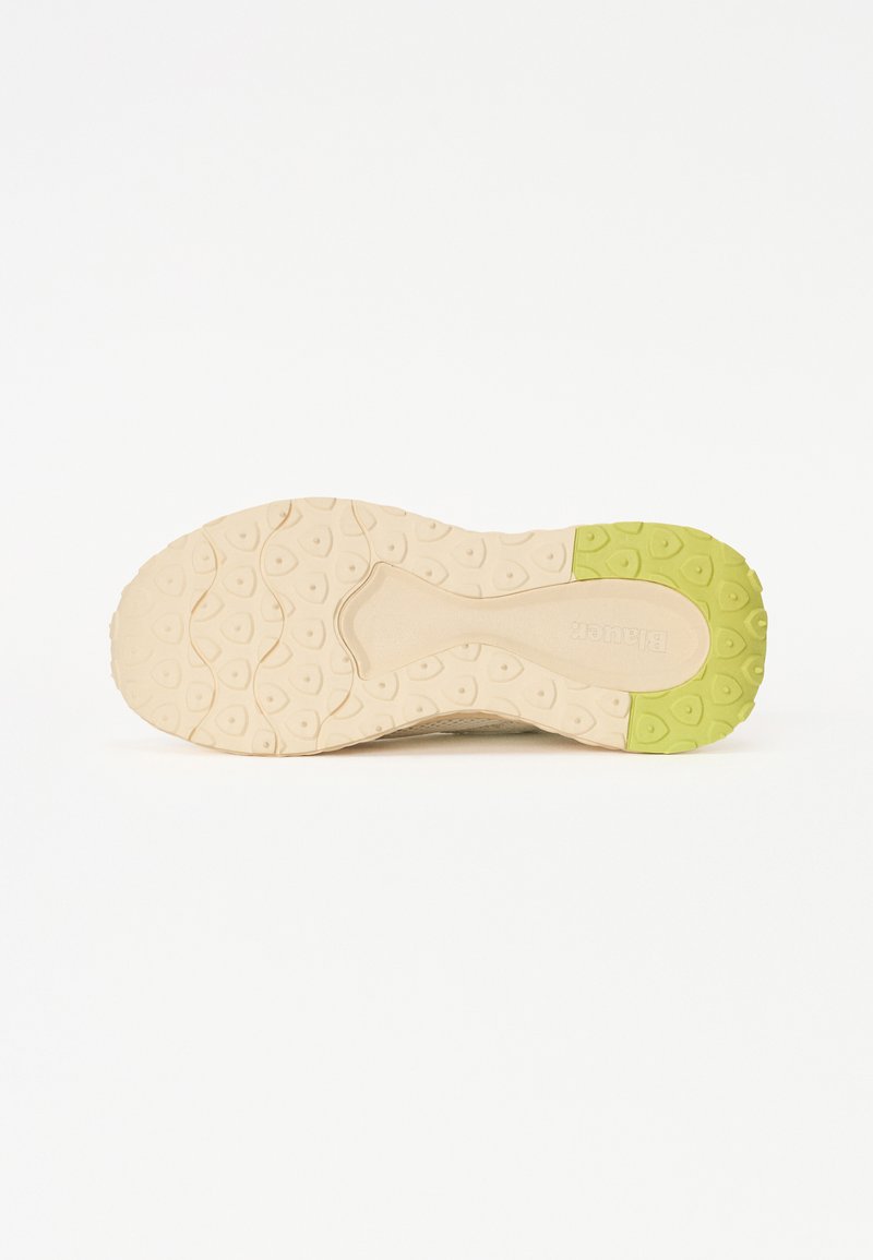 Suola di scarpa beige con superficie a motivo; accentuazione verde sul tallone; presa texturizzata con forme circolari e ovali.