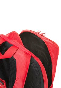 Mochila roja con apertura con cremallera, que presenta un exterior de tejido texturizado y un panel trasero de malla negra en el interior para mayor transpirabilidad.