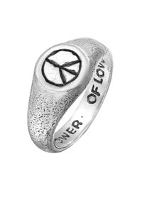Sökringe med en texturerad yta, rund fredssymbol högst upp, graverad med "KRAFTEN AV KÄRLEK" på den inre kanten.