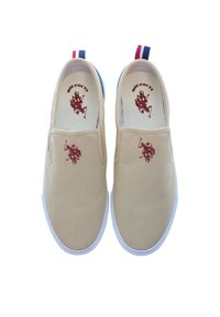 Beige canvas slip-on shoes with white rubber soles. Features a red polo player logo and blue and red accent on the heel.