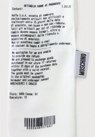 Politique de retour et instructions d'échange en italien et en anglais sur une étiquette blanche de vêtement avec une étiquette de marque Moschino.