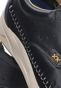 Zapatos de cuero azul marino con costuras blancas, puntera redonda y superficie texturizada. Presenta acentos amarillos y una suela beige.