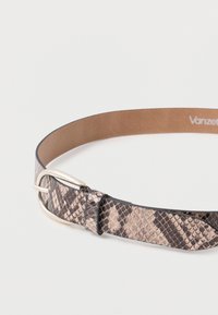 Belte med python-mønster i beige og svarte toner. Har en glatt skinninnside og en sølvfarget spenne. Flat profil, justerbar passform.